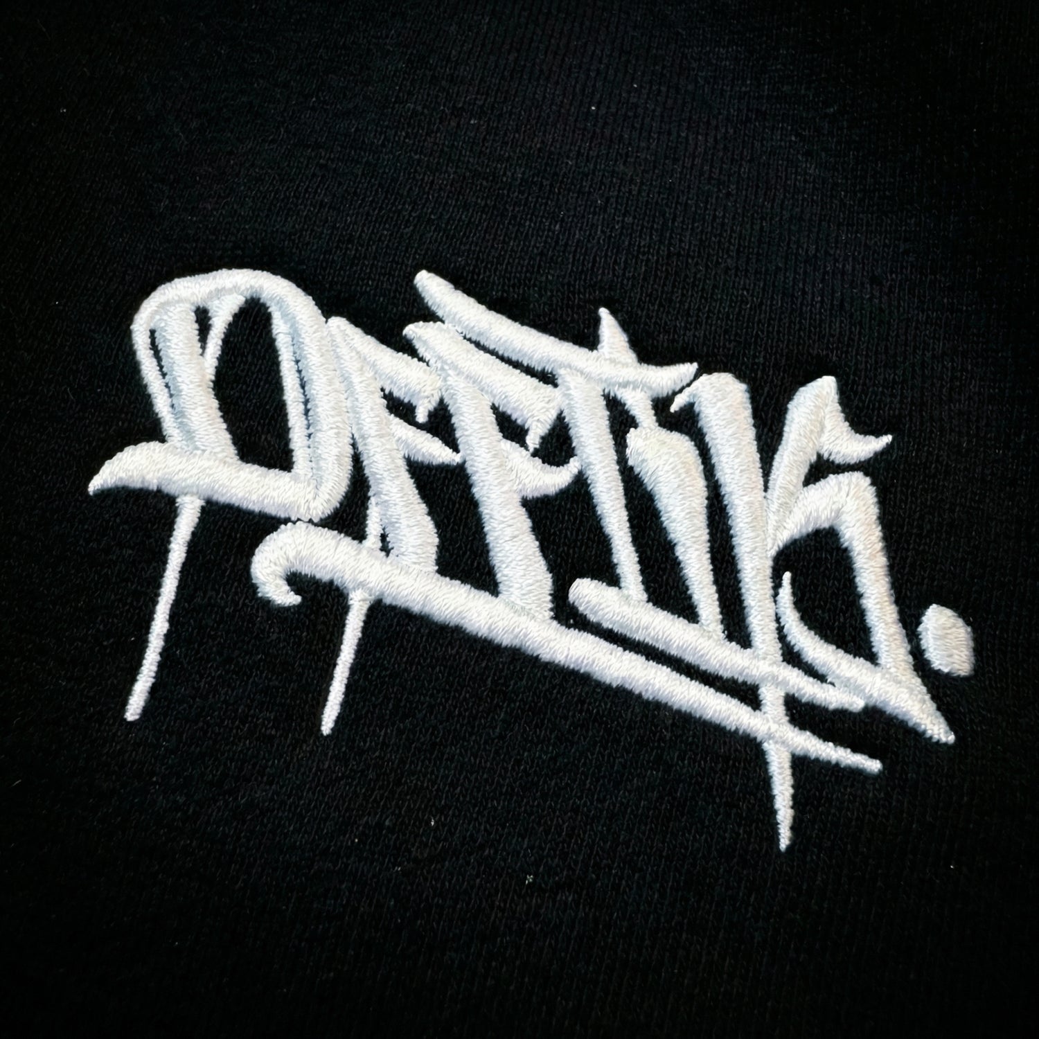 White embroidered text on a black background
