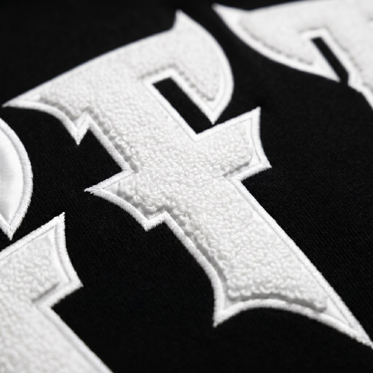 Close-up of a white cross emblem on a black background
