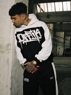 Person wearing a black and white hoodie with visible branding in an urban setting