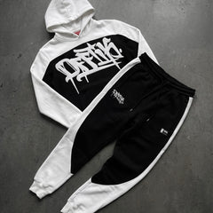 White and black hoodie with graphic design on a gray surface