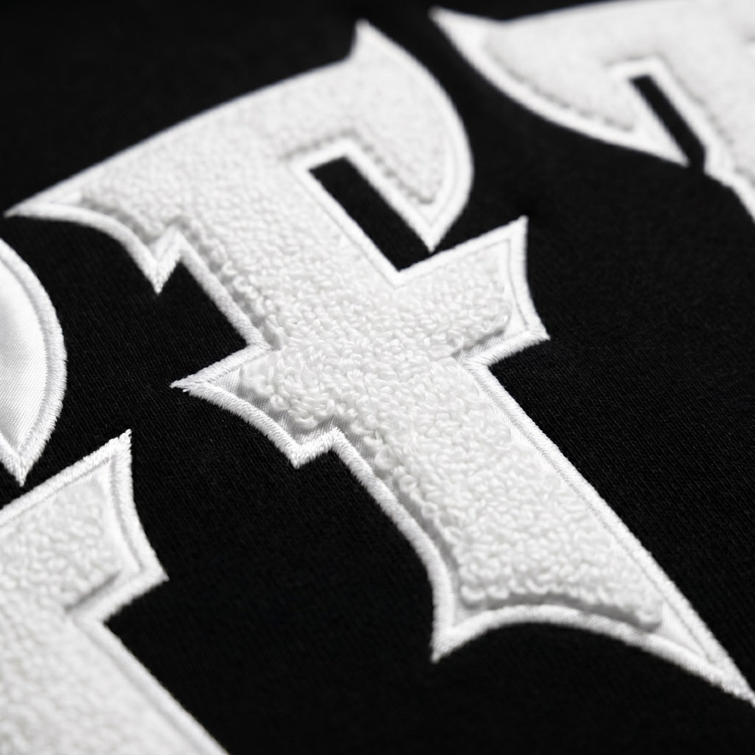 Close-up of a white cross emblem on a black background, image 7