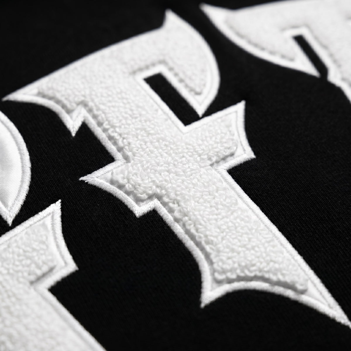Close-up of a white cross emblem on a black background, image 7