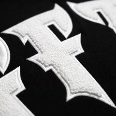 Close-up of a white cross emblem on a black background